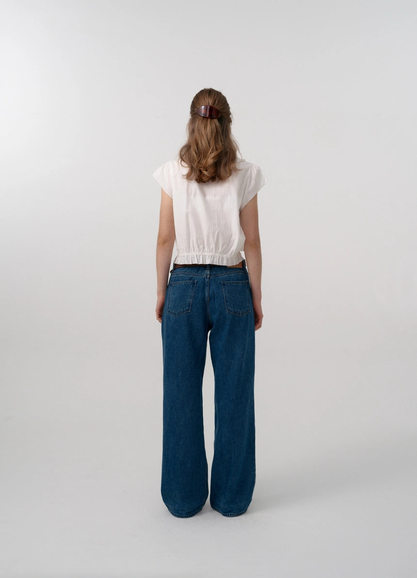 The Daina Ruffle Collar Blouse features a delicate lace trim along the hem, adding a refined and expert touch to its design. Crafted from a soft, ivory cotton fabric, this blouse combines sophisticated details such as a ruffled collar and precise stitching to ensure both elegance and durability. Ideal for those who appreciate meticulous craftsmanship and understated femininity.