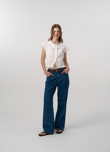 The Daina Ruffle Collar Blouse features a delicate lace trim along the hem, adding a refined and expert touch to its design. Crafted from a soft, ivory cotton fabric, this blouse combines sophisticated details such as a ruffled collar and precise stitching to ensure both elegance and durability. Ideal for those who appreciate meticulous craftsmanship and understated femininity.