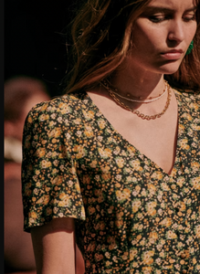 The Vivienne Dress by Sezane offers a graceful midi length silhouette with elegant short sleeves and a refined V neckline. Its button placket features covered buttons, adding a subtle yet polished touch. Fully lined for comfort and quality, this dress embodies sophisticated charm ideal for both formal and special occasions.