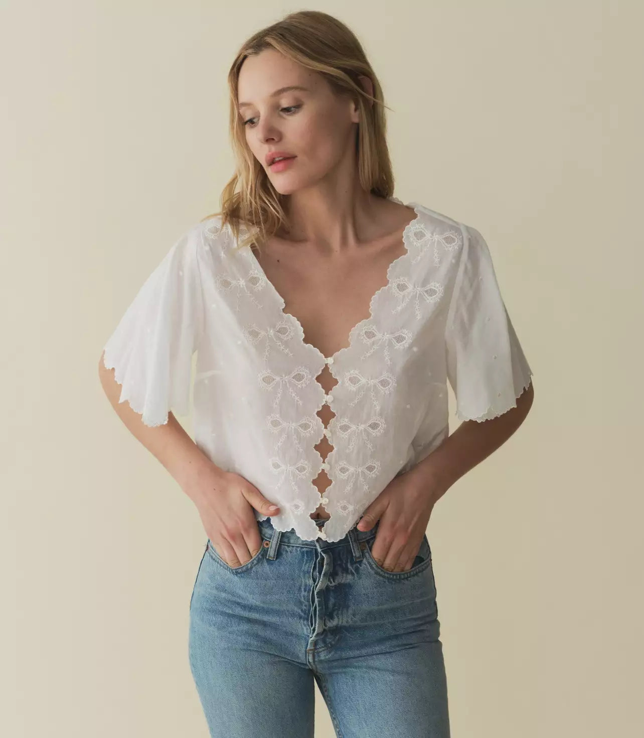 Indulge in the romantic charm of the Kacy Embroidered Top by DOEN, crafted with 100% organic cotton voile and adorned with delicate bow embroidery and playful cutouts. Inspired by vintage Victorian blouses, this top features elegant scalloped details and breezy sleeves that add a touch of sophistication. Elevate your wardrobe with this luxurious and exclusive piece.