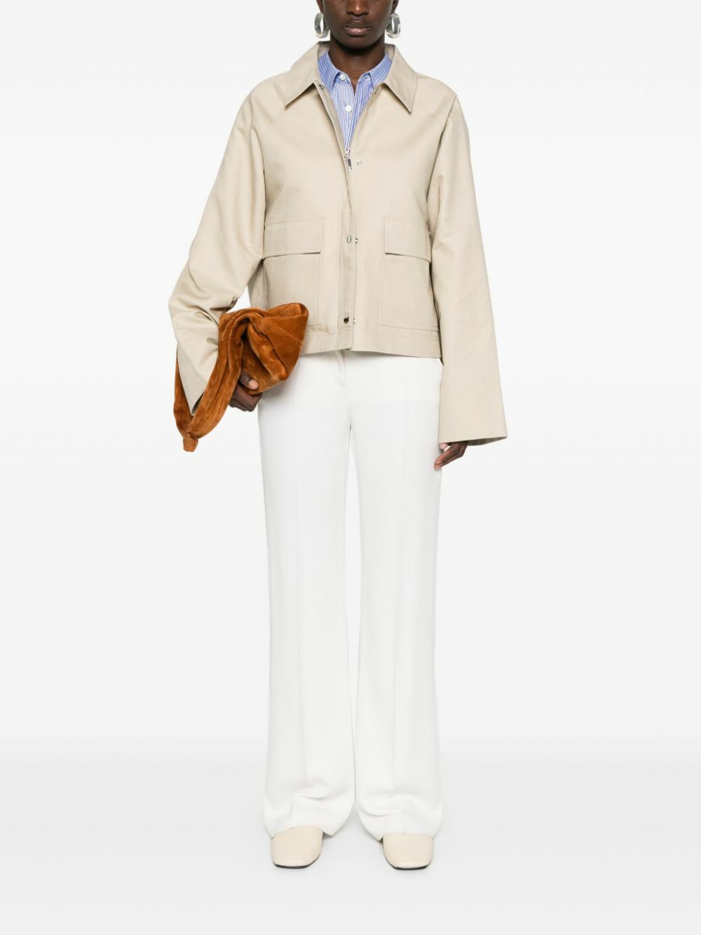 Elevate your wardrobe with this TOTEME organic cotton cropped jacket, crafted from sustainable sand beige canvas. The tailored silhouette features a classic collar, raglan sleeves, and a straight hem for effortless sophistication. Practical front flap pockets and full lining provide everyday functionality, while the dual press-stud and zip fastening offers versatile styling options. A refined essential that transitions seamlessly from casual to polished occasions.
