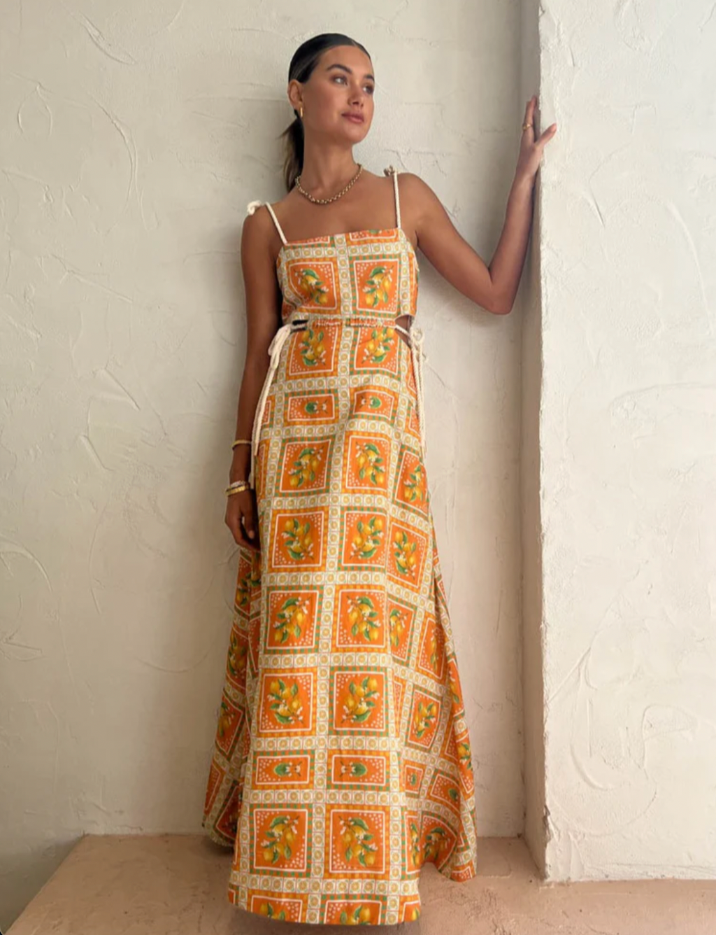 Embrace the essence of a Sicilian summer with the Lemonade Tie Maxi Dress in Orange Mosaic. Made from a breathable linen-cotton blend and fully lined, this dress offers comfort through long summer days. Its straight neckline and fitted bodice flatter the silhouette, while adjustable rope shoulder and waist ties provide a personalized fit. 