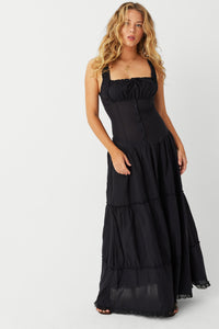 The Christabelle Dress in Black is the perfect addition to your spring wardrobe. Designed with smocking details and ruffle accents, this maxi dress exudes a feminine and playful look. With fixed buttons and a prairie silhouette, it's both stylish and comfortable. Slip into it and your favorite pair of pumps for the ultimate weekend outfit.