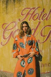 The Noddy Dress in Orange Plates by Palm Noosa showcases a refined midi silhouette crafted from 100% premium linen. Its relaxed fit is complemented by elegant blouson sleeves with elasticated cuffs, a sleek stand collar, and a button-front design. A matching buckle belt allows you to define your waist gracefully, enhancing the dress’s flattering drape. Perfect for an effortless yet polished look, this dress combines comfort and style with sophisticated ease. Please consult our size guide for the best fit.