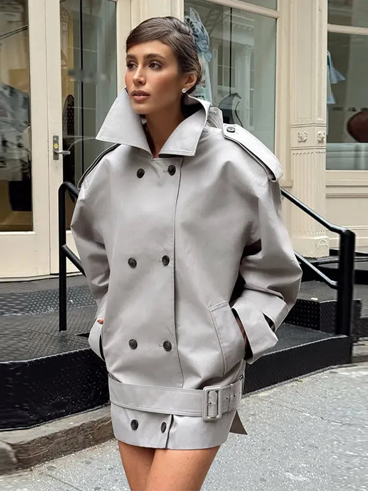 The Major Trench Jacket by Helsa combines timeless design with functional details for a sophisticated look. Crafted from durable gabardine, it features a front button closure and padded shoulders for comfort and structure. Epaulettes and belted cuffs enhance its refined style, while side seam pockets add practicality. An optional belt allows for a tailored fit, making this jacket a versatile layer suitable for all seasons. 