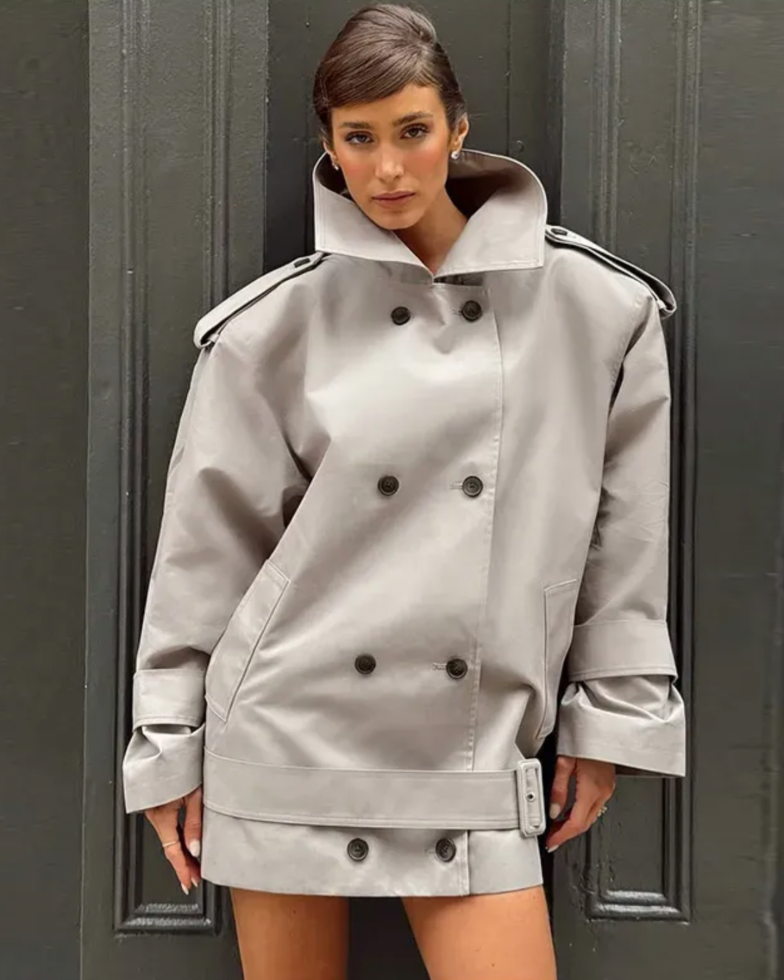 The Major Trench Jacket by Helsa combines timeless design with functional details for a sophisticated look. Crafted from durable gabardine, it features a front button closure and padded shoulders for comfort and structure. Epaulettes and belted cuffs enhance its refined style, while side seam pockets add practicality. An optional belt allows for a tailored fit, making this jacket a versatile layer suitable for all seasons. 