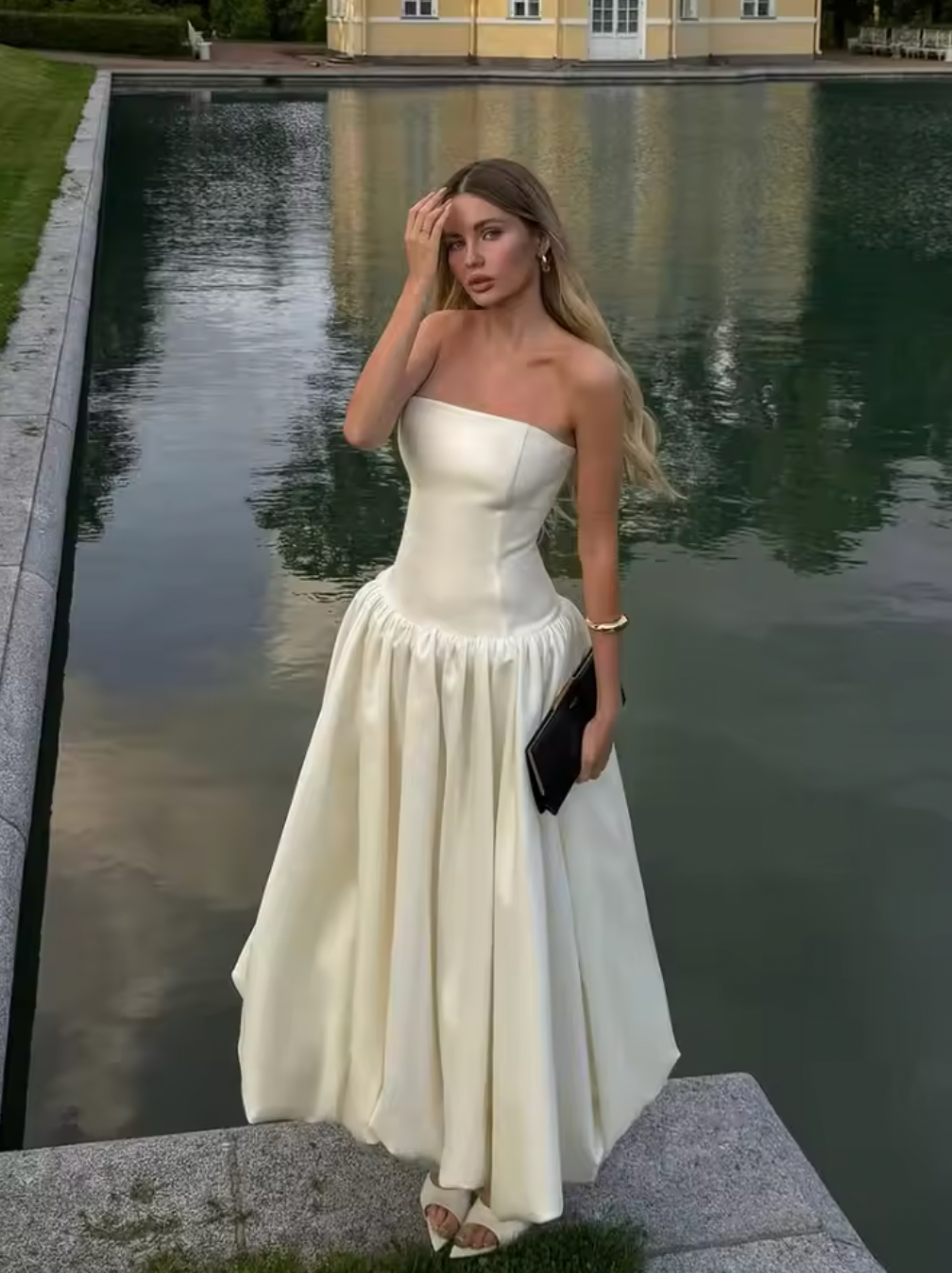 The Chateau Midi Dress combines timeless elegance with modern design, featuring a solid, strapless bodice and an A-line silhouette that flatters every figure. Its high waist and pleated skirt create a refined, flowing shape, perfect for summer events and sophisticated parties. Crafted to ensure comfort without sacrificing style, this chic sleeveless dress is an ideal choice for women seeking effortless grace in warm weather.