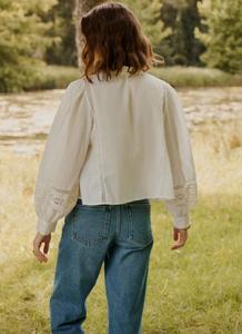 La blouse Tokyo allie légèreté et élégance grâce à son coton biologique écru, respirant et durable. Son col montant froncé, orné de dentelles délicates, crée un jeu de textures raffiné. Les manches longues bouffantes ajoutent un volume maîtrisé, tandis que les fronces sur l’avant apportent une finition structurée. Ce top versatile offre à la fois confort et style, idéal pour sublimer une silhouette avec discrétion et sophistication.