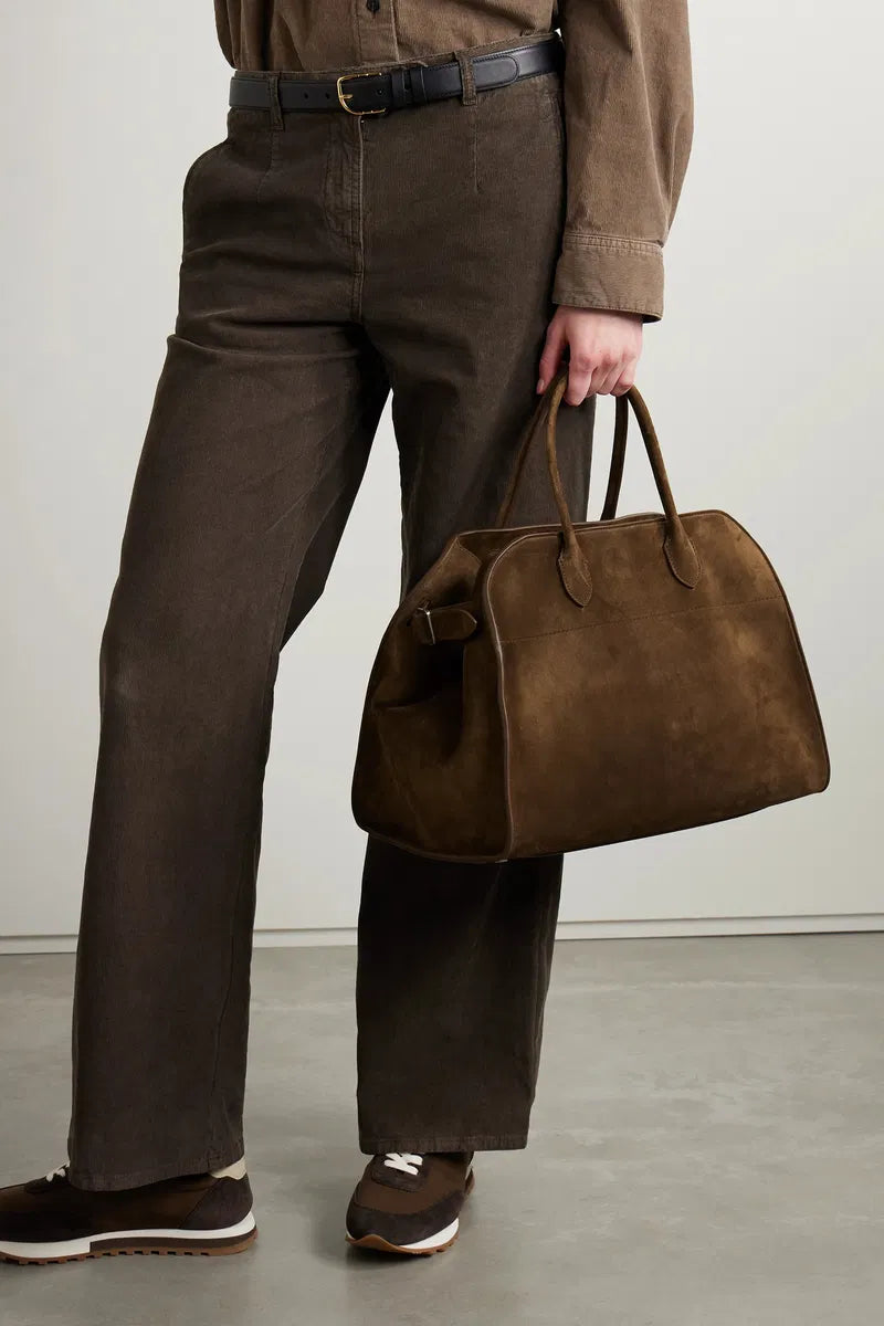 Gracefully structured top handle bag from The Row, crafted in soft calfskin suede with belted, gusseted side panels and a sleek interior.