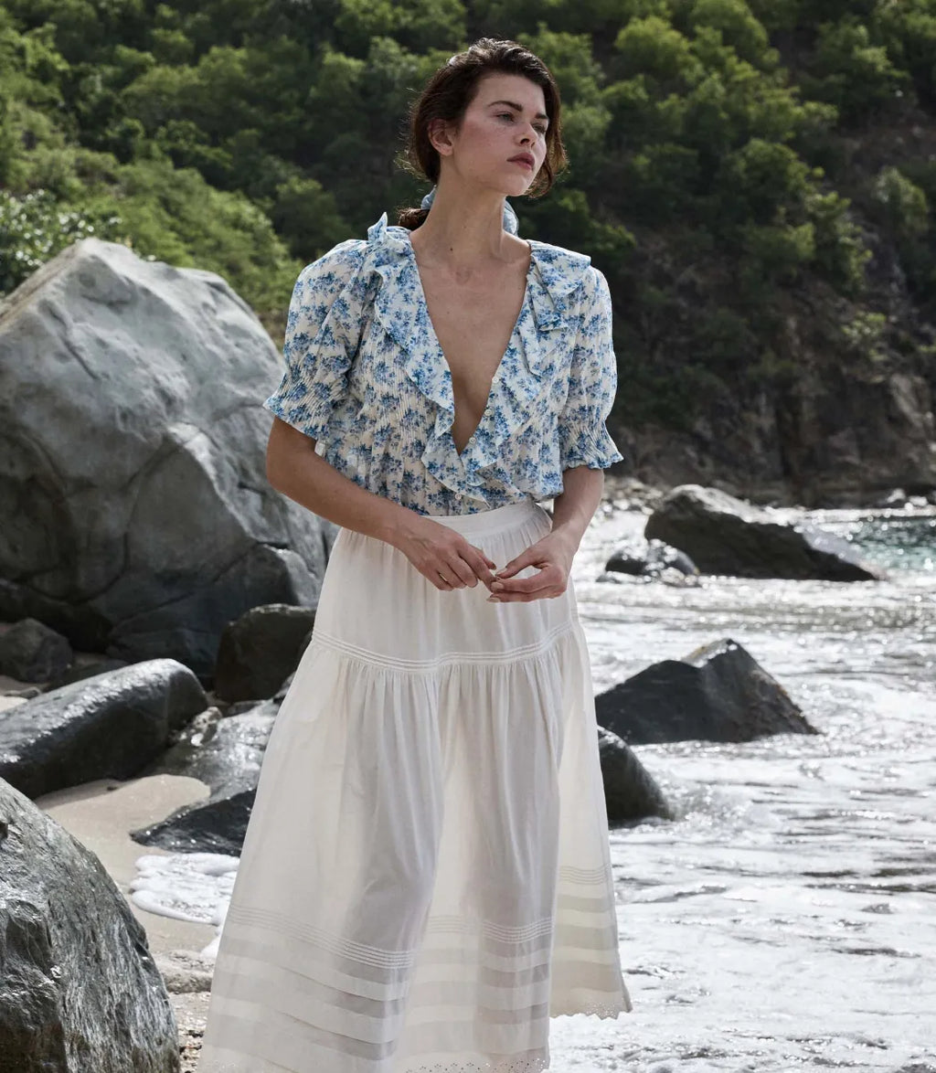 The Henri top in Bleu Rosier Floral offers a refined yet approachable style, crafted from soft fabric adorned with a delicate blue floral pattern. Its subtle ruffle detail and V-neckline enhance the rustic charm while the gently fitted silhouette flatters the figure. Pair it effortlessly with blue denim for versatile looks that transition seamlessly from casual daywear to polished evening ensembles with the right footwear choice.