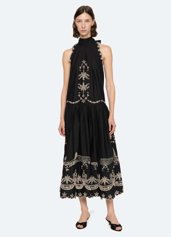 The Kingsley embroidered tank dress by SEA NY showcases intricate embroidery throughout its design, offering a refined and elegant appeal. It features a high neckline that adds a sophisticated touch, complemented by a delicate back bow tie for adjustable fit and added charm. The scalloped hemline enhances the dress's feminine silhouette, making it an exceptional choice for those seeking a polished yet distinctive look.