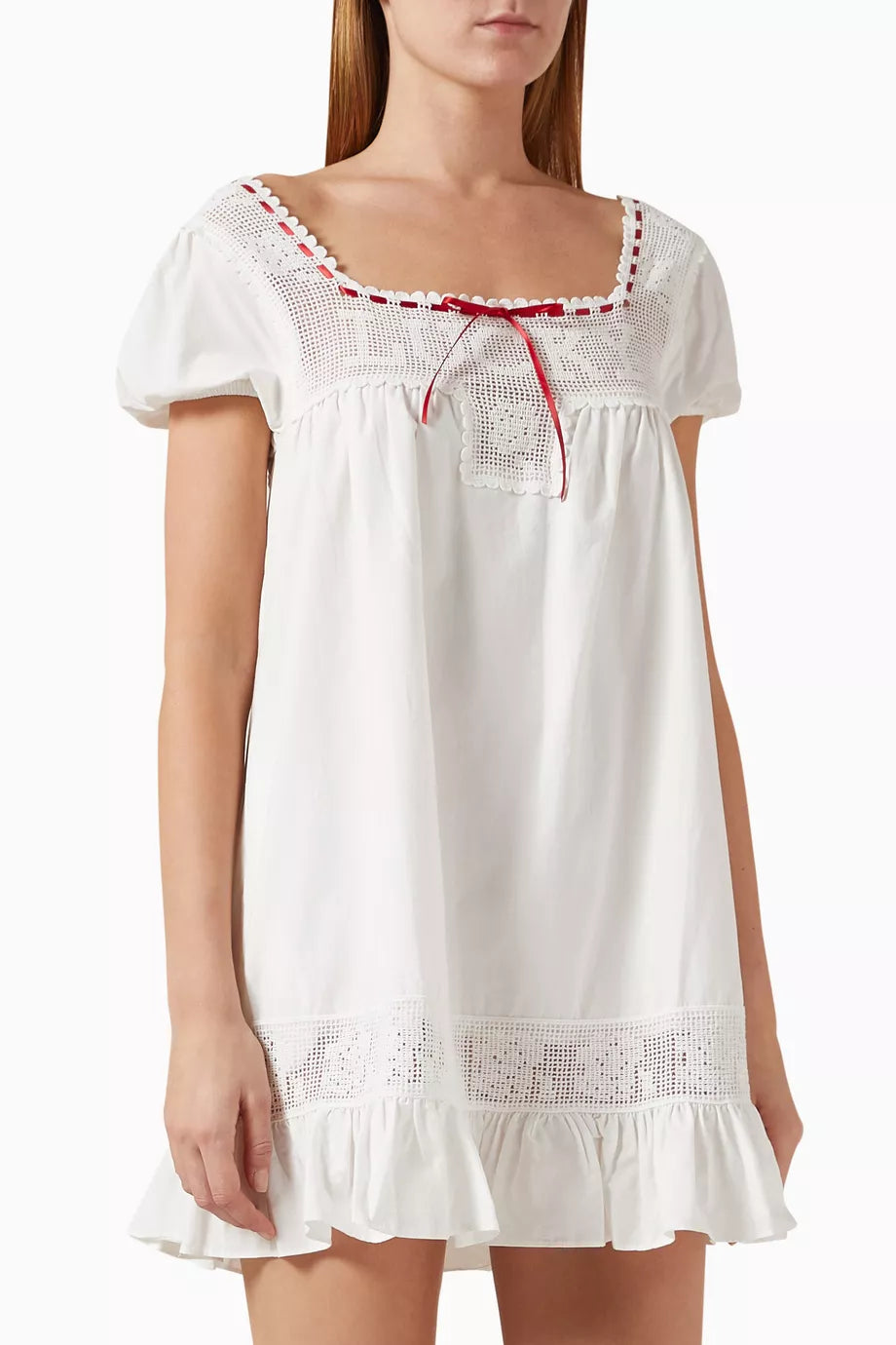 The Lucky Babydoll Mini Dress in cotton by Frankies Bikinis poplin blends prairie-inspired charm with modern flair. Featuring puff sleeves and a bow-detailed bust, its crisp fabric shapes a flattering babydoll silhouette. This versatile piece pairs effortlessly with cowboy boots or strappy sandals, making it an ideal choice for weekend outings and summer strolls.