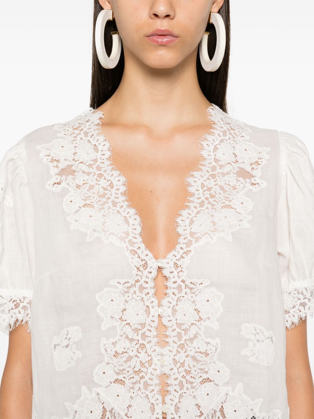 Introducing the luxurious Idella top by DOEN. Made from high-quality, soft ramie and delicate guipure lace, this top boasts a flattering V-neck and elegant scallop hem. Its front button fastening and short puff sleeves add a touch of sophistication to this white beauty. Upgrade your wardrobe with the Idella top.