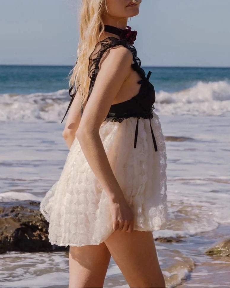 The Poppy Mini Dress from For Love & Lemons exudes luxury and sophistication with its 3D rose flock dot fabric and contrast satin cups. Underwire provides support while chiffon ruffled straps add a touch of femininity. The sheer skirt and keyhole back add allure, while the S-hook and invisible zip closures ensure a perfect fit. Fully lined for added comfort.