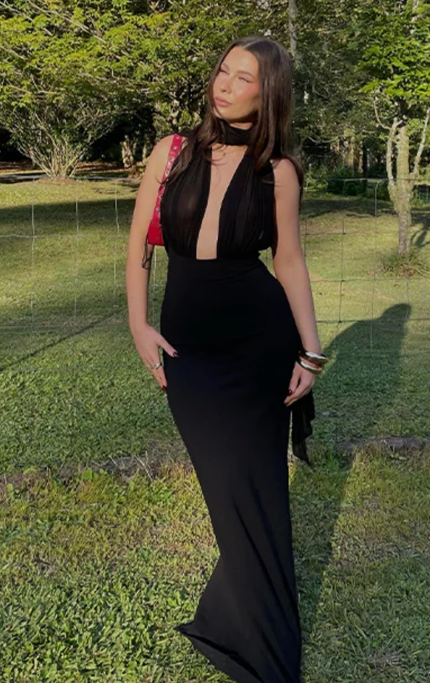 The Amber Maxi Dress by Helsa Studio combines refined elegance with bold design. Featuring a sculpted silhouette and delicate draping, it flatters the figure while the halter neckline and sheer scarf add refined sophistication. The flared hem enhances graceful movement, complemented by a sheer bodice that introduces a confident, modern edge. Perfect for special occasions, this dress delivers a distinctive and memorable style with expert craftsmanship.