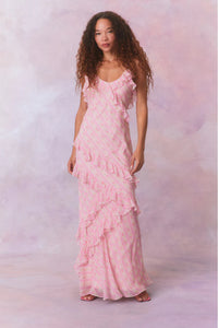 Designed with elegance and movement in mind, the Rialto Maxi Dress in Strawberry Macaroon captivates with its chiffon fabric and cascading asymmetrical ruffles that flow from neckline to hem. Its slightly fitted silhouette enhances your figure with subtle allure, while a discreet side seam zipper ensures a seamless fit. Perfect for dancing or any refined occasion, this dress combines comfort with sophisticated style effortlessly.