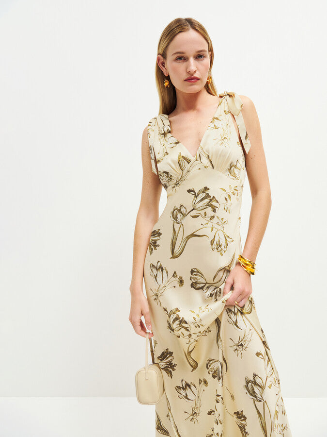 The Pernille Silk Dress exudes understated elegance with its delicate tie straps and flattering v-neck design. Crafted from lightweight silk charmeuse, it offers a graceful drape and subtle sheen. The Ivory colorway features a more substantial, higher-quality silk, lending a richer feel and justifying its exclusive price. This refined piece promises timeless sophistication for those who appreciate exquisite craftsmanship and luxurious fabric.
