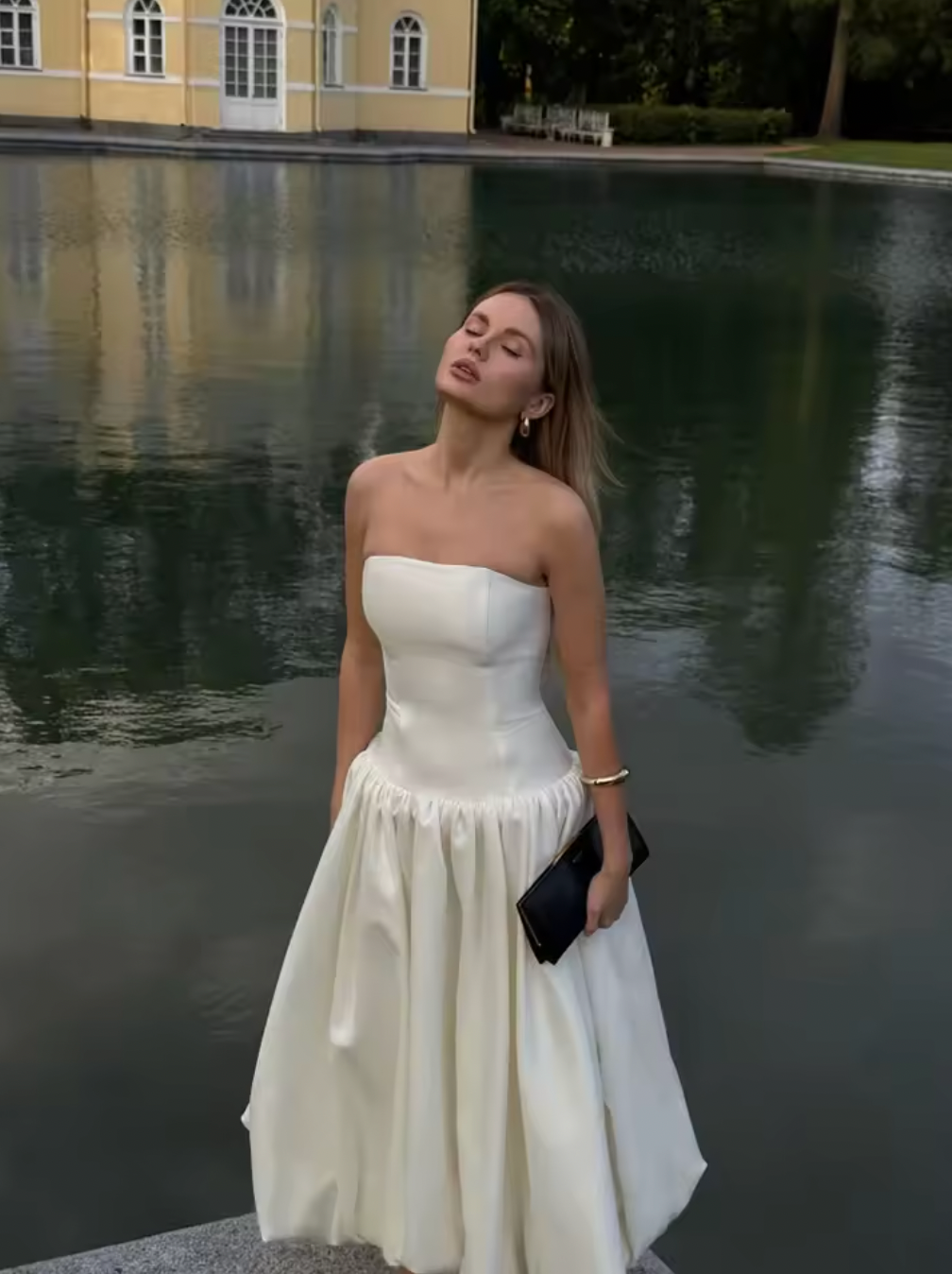 The Chateau Midi Dress combines timeless elegance with modern design, featuring a solid, strapless bodice and an A-line silhouette that flatters every figure. Its high waist and pleated skirt create a refined, flowing shape, perfect for summer events and sophisticated parties. Crafted to ensure comfort without sacrificing style, this chic sleeveless dress is an ideal choice for women seeking effortless grace in warm weather.