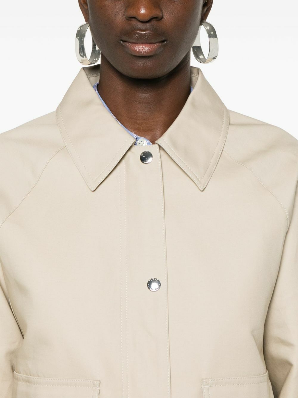 Elevate your wardrobe with this TOTEME organic cotton cropped jacket, crafted from sustainable sand beige canvas. The tailored silhouette features a classic collar, raglan sleeves, and a straight hem for effortless sophistication. Practical front flap pockets and full lining provide everyday functionality, while the dual press-stud and zip fastening offers versatile styling options. A refined essential that transitions seamlessly from casual to polished occasions.