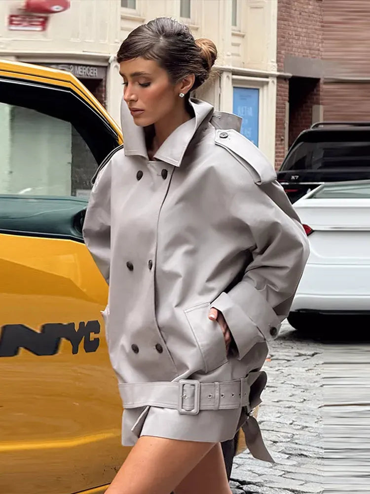 The Major Trench Jacket by Helsa combines timeless design with functional details for a sophisticated look. Crafted from durable gabardine, it features a front button closure and padded shoulders for comfort and structure. Epaulettes and belted cuffs enhance its refined style, while side seam pockets add practicality. An optional belt allows for a tailored fit, making this jacket a versatile layer suitable for all seasons. 