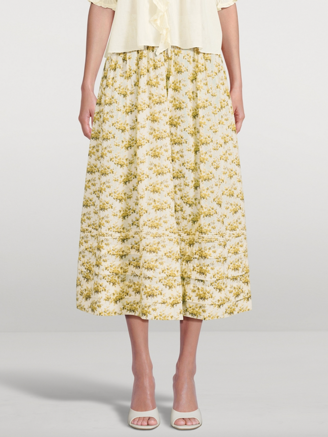 The Marcie Maxi Skirt in Floral Print by Doen is crafted from soft, lightweight organic cotton voile, featuring a Victorian-inspired Rosier Floral design. It boasts a high waist with an invisible side seam zipper, offering a seamless fit. The ankle-grazing full skirt is detailed with elegant pintucks, combining classic style with refined craftsmanship. Certified to the Global Organic Textile Standard, this skirt ensures both quality and sustainability.