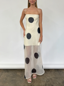 The Mila Maxi Dress in Ivory Polka by Nicole features sheer organza adorned with striking polka dots, shaping a sleek column silhouette. Its half-lined design and elasticated back ensure comfort and adaptability, while the option to wear it with or without straps provides versatile styling choices perfect for refined occasions.