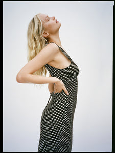 The Stephanie - Paradiso Noir is a silk dress designed for effortless elegance. Its adjustable back tie shapes the waist perfectly, while wide straps offer comfort and bra coverage. The V-neckline subtly enhances the décolletage, and its mid-calf length flatters a range of heights, revealing just the right amount of leg. Versatile for styling, it pairs beautifully with boots for a 90s-inspired look or delicate heels for a more refined finish. A timeless piece that effortlessly elevates your wardrobe.
