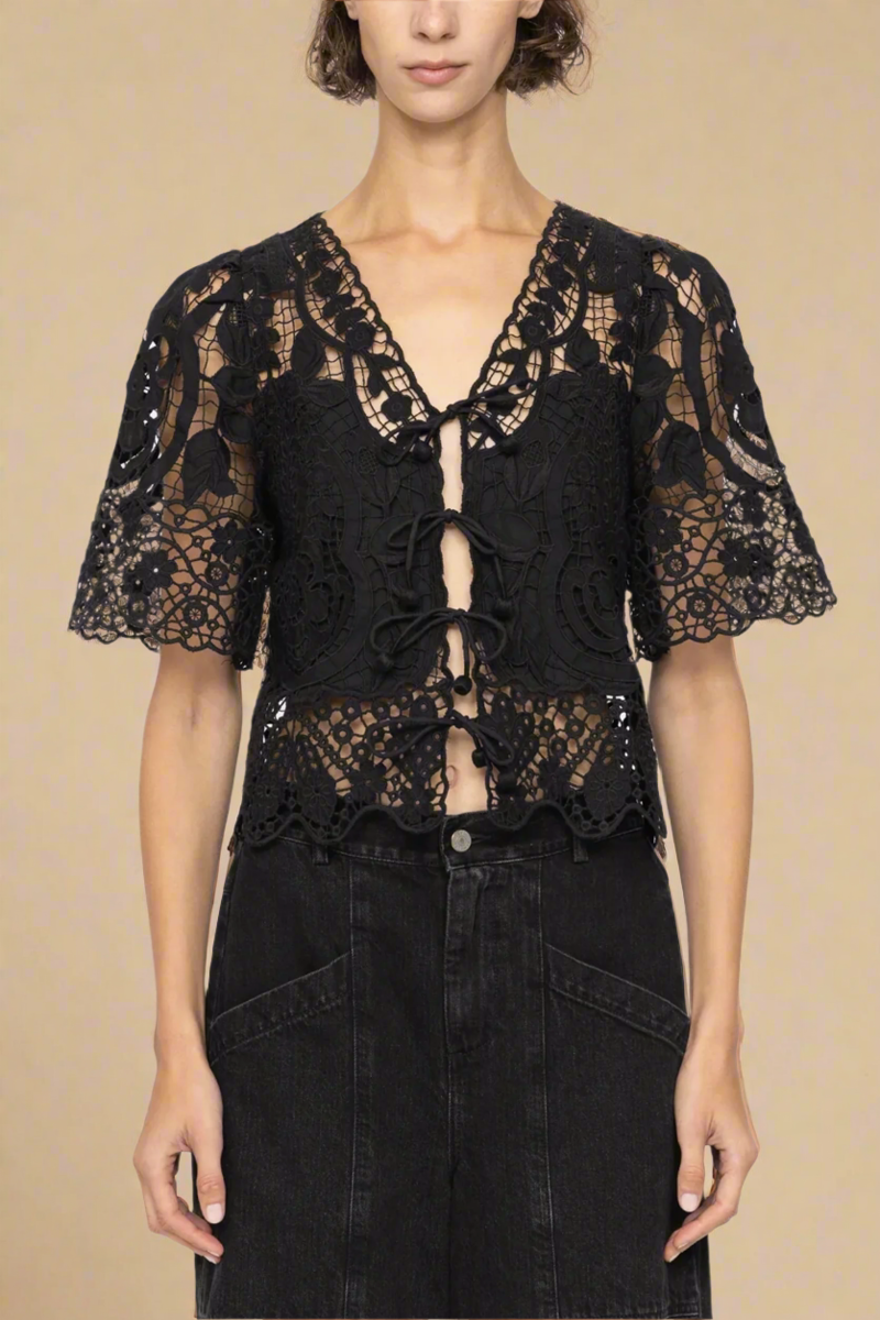 The Gianna Tie Top from Sea New York blends delicate lace detailing with a relaxed fit for effortless elegance. Crafted from 100% cotton with polyester embroidery, it features short flowy sleeves and a front tie closure, delivering both comfort and a romantic silhouette. Ideal for those seeking a refined yet easygoing style.