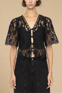 The Gianna Tie Top from Sea New York blends delicate lace detailing with a relaxed fit for effortless elegance. Crafted from 100% cotton with polyester embroidery, it features short flowy sleeves and a front tie closure, delivering both comfort and a romantic silhouette. Ideal for those seeking a refined yet easygoing style.