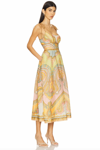 The Maxine Picnic Midi Dress by Zimmermann features a boned bodice with a smocked back for a tailored yet flexible fit. Crafted from lightweight linen, it ensures breathable comfort during warm days. The unlined design pairs with self-tie shoulder straps and a hidden back zipper closure for a sleek silhouette. Functional side seam pockets add practicality without compromising style, making this dress an expert choice for effortless, elegant summer wear.