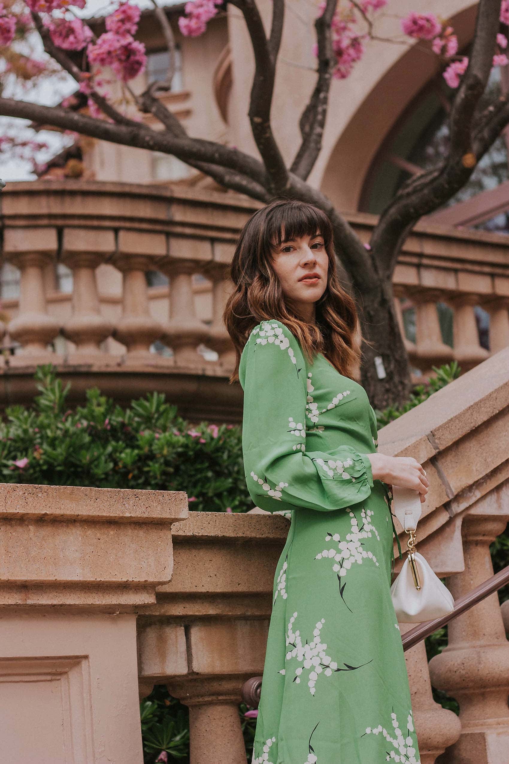 Show off your playful side in the Violette Midi Dress! This stunning lightweight silk dress features a white floral print on a vibrant green background. With 3/4 length sleeves and a comfortable wrap style, you can adjust the waist with the string tie closure. Embrace your love for summer in this unique and stylish dress!