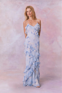 Designed with elegance and movement in mind, the Rialto Maxi Dress in Whisper Blue captivates with its chiffon fabric and cascading asymmetrical ruffles that flow from neckline to hem. Its slightly fitted silhouette enhances your figure with subtle allure, while a discreet side seam zipper ensures a seamless fit. Perfect for dancing or any refined occasion, this dress combines comfort with sophisticated style effortlessly.