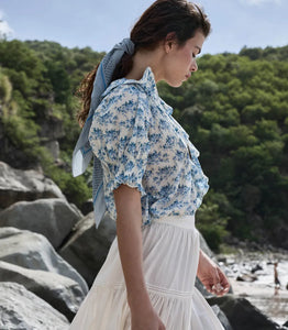 The Henri top in Bleu Rosier Floral offers a refined yet approachable style, crafted from soft fabric adorned with a delicate blue floral pattern. Its subtle ruffle detail and V-neckline enhance the rustic charm while the gently fitted silhouette flatters the figure. Pair it effortlessly with blue denim for versatile looks that transition seamlessly from casual daywear to polished evening ensembles with the right footwear choice.