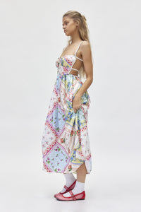 The Cassandra Dress by For Love & Lemons offers a chic and sophisticated look with its midi length, square neckline, and open back design. Its silky, patchwork quilted fabric adds texture and interest, while the fitted bodice with rose detail and double back ties create a flattering silhouette. Perfect for any occasion, with adjustable closures for a customizable fit.