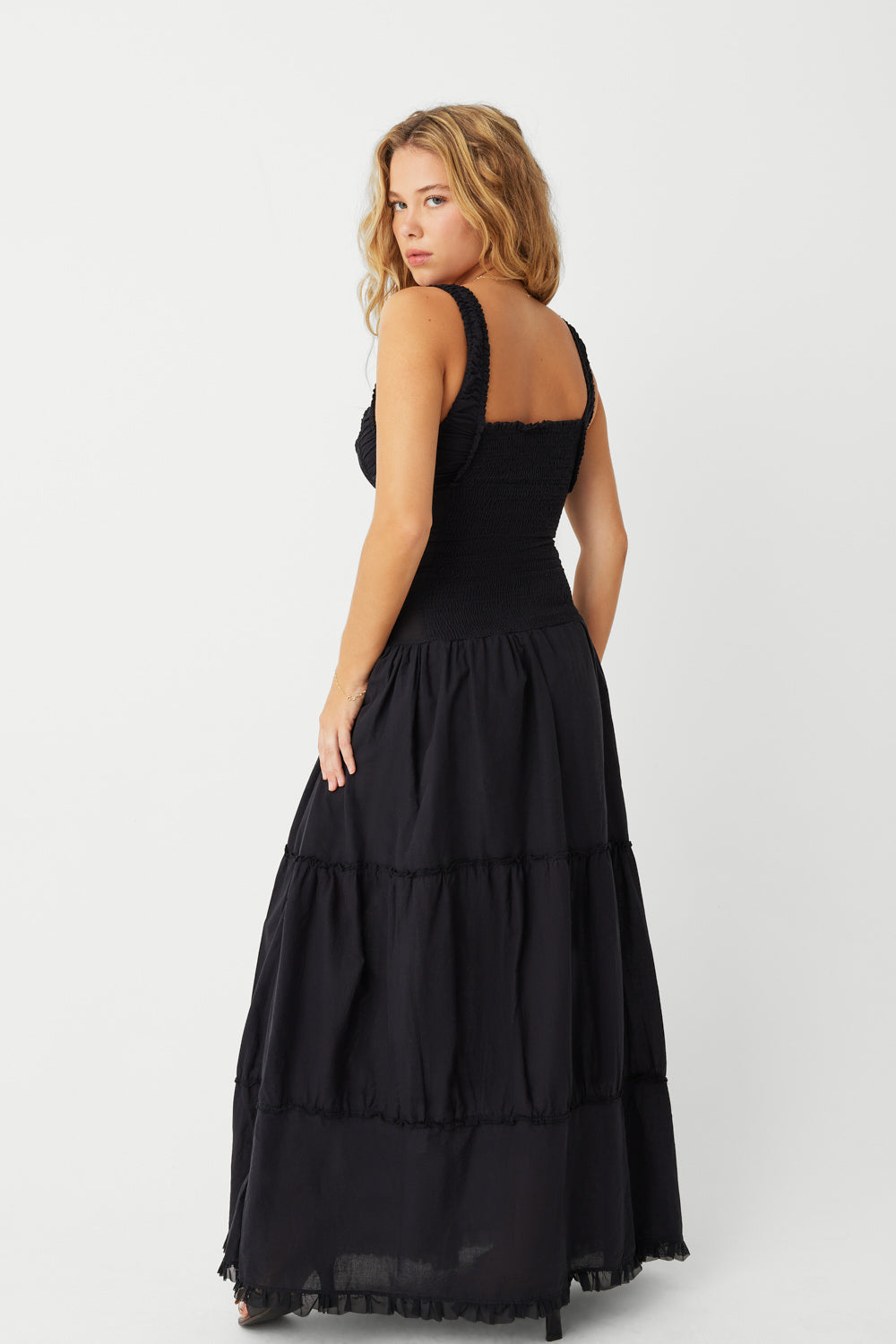 The Christabelle Dress in Black is the perfect addition to your spring wardrobe. Designed with smocking details and ruffle accents, this maxi dress exudes a feminine and playful look. With fixed buttons and a prairie silhouette, it's both stylish and comfortable. Slip into it and your favorite pair of pumps for the ultimate weekend outfit.