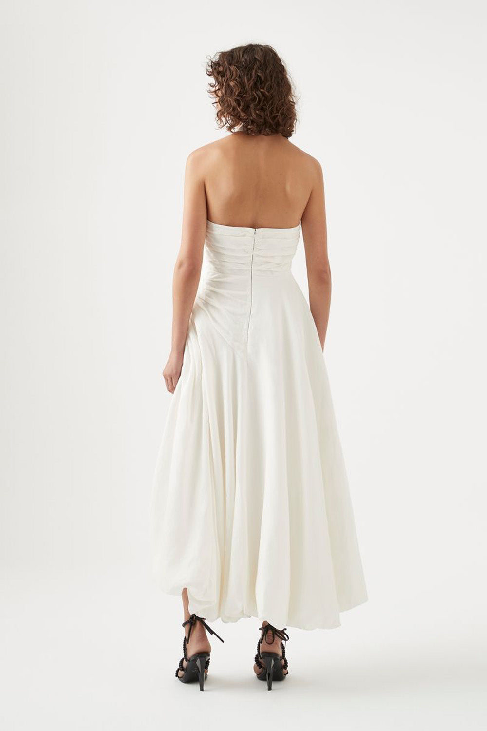 Elevate your elegance with the Mika Draped Split Maxi Dress in Ivory by Aje. Crafted from midweight ruched linen, this fully lined dress features a sophisticated asymmetrical hem that flows gracefully. The exposed back zipper adds a modern edge, while the gold-tone and faux pearl accents on the halterneck strap enhance its refined charm. Perfect for making a timeless statement at any upscale event.