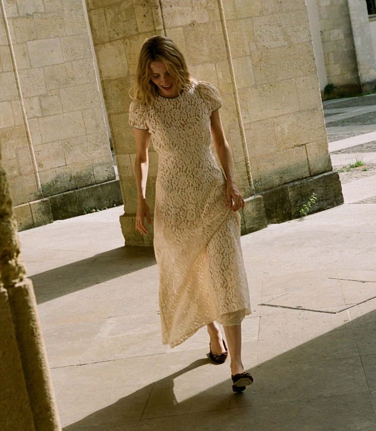 The Katarina Dress by Doen features a refined silhouette crafted from delicate corded lace, enhanced with satin trims along the neckline and puffed sleeves. Designed with a full lining, it offers both elegance and assured coverage, making it a sophisticated choice for special occasions.