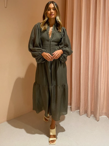 Indulge in luxury with the Charlotte High Neck Midi Dress in Khaki from Shona Joy. Crafted with exquisite detail, this dress features oversized draped sleeves, a fitted waist, and a free-flowing tiered midi skirt. Perfect for weddings, birthdays, and dinner dates, this dress will make you feel elegant and exclusive.