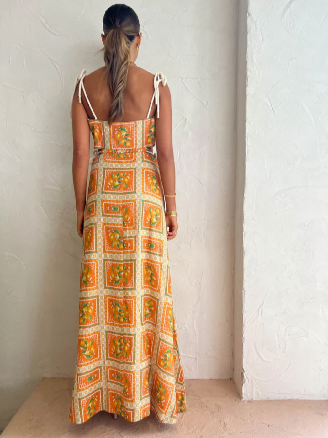 Embrace the essence of a Sicilian summer with the Lemonade Tie Maxi Dress in Orange Mosaic. Made from a breathable linen-cotton blend and fully lined, this dress offers comfort through long summer days. Its straight neckline and fitted bodice flatter the silhouette, while adjustable rope shoulder and waist ties provide a personalized fit. 