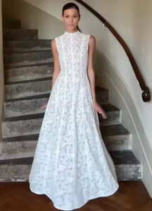 Introducing the luxurious Louise Dress, a must-have for any elegant and exclusive wardrobe. Crafted with intricate lace details, this pleated white dress exudes sophistication and grace. Its high neckline and cinched waist create a flattering silhouette, perfect for any spring event. Step into the future of fashion with this stunning piece from our cocktail collection.