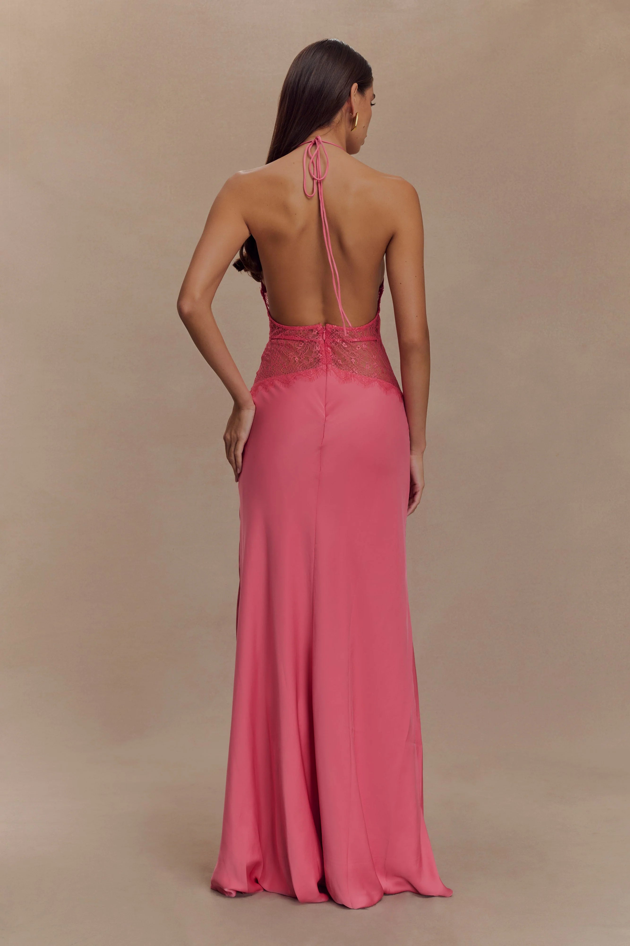 The Dinah Satin Dress offers a refined blend of elegance and allure with its halter tie V-neckline and softly gathered bust. Crafted with a sheer lace body that gracefully follows your silhouette, it features a dramatic low back and a maxi length for timeless sophistication. Partially lined and equipped with an invisible zip, this dress ensures a flawless fit and subtle coverage, perfect for making a confident statement at any special occasion.