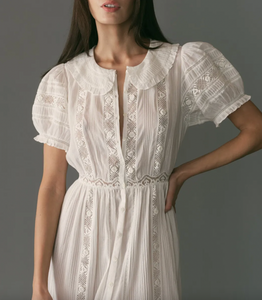 Indulge in timeless elegance with our Phoebe Lace Dress. Made from the softest organic cotton voile, it features delicate pintucks, inset lace, and a ruffled Peter Pan collar for a Victorian-inspired look. The fitted waist and mother-of-pearl buttons add a touch of sophistication, making it perfect for any occasion.