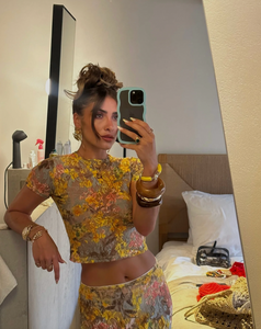 This elegant set features a multi-floral maxi skirt with a form-fitting silhouette that sits mid to low waist, crafted from luxurious stretchy lace for comfort and style. Complemented by a coordinating semi-sheer floral baby t-shirt with cap sleeves and a cropped shape, both pieces showcase a bright summer palette and timeless design, perfect for a sophisticated seasonal look.