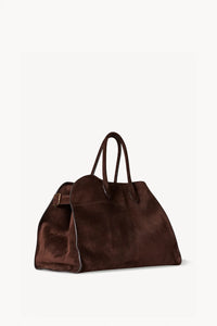 Gracefully structured top handle bag from The Row, crafted in soft calfskin suede with belted, gusseted side panels and a sleek interior.