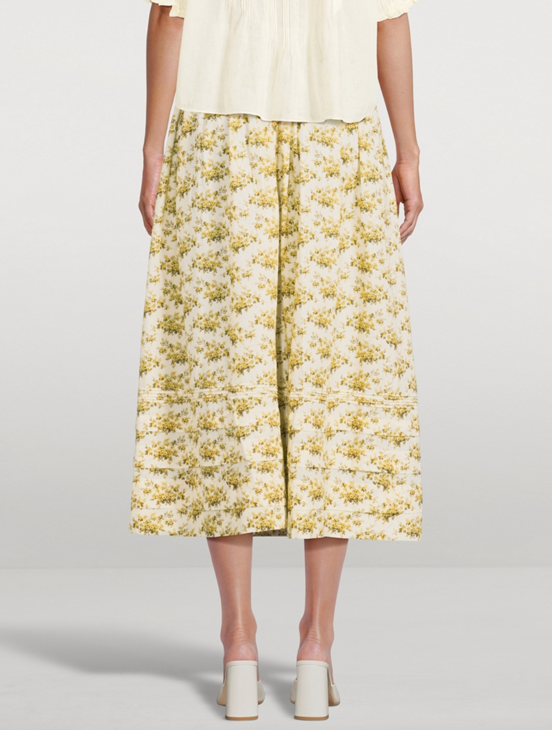 The Marcie Maxi Skirt in Floral Print by Doen is crafted from soft, lightweight organic cotton voile, featuring a Victorian-inspired Rosier Floral design. It boasts a high waist with an invisible side seam zipper, offering a seamless fit. The ankle-grazing full skirt is detailed with elegant pintucks, combining classic style with refined craftsmanship. Certified to the Global Organic Textile Standard, this skirt ensures both quality and sustainability.