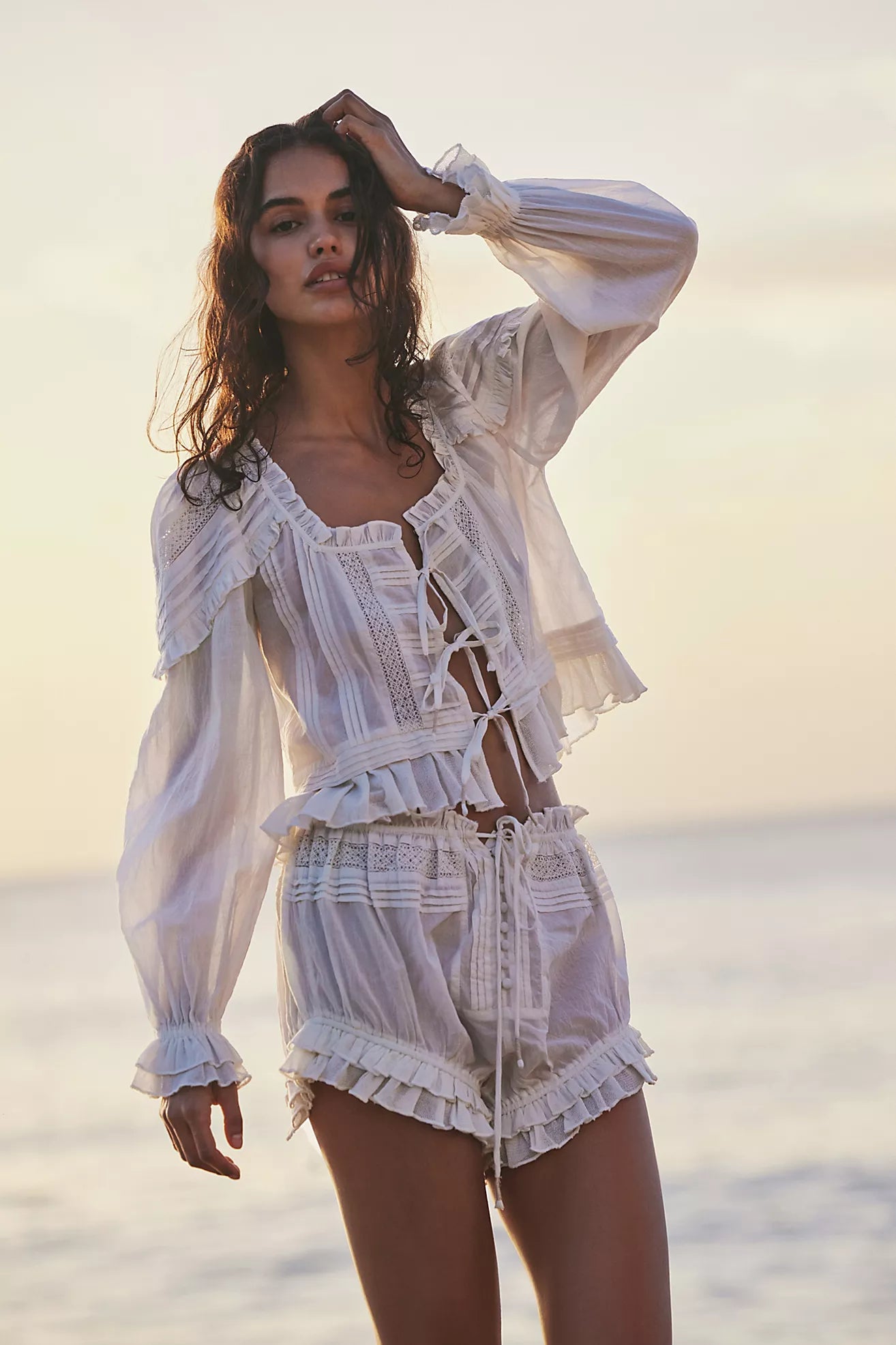 Embrace timeless elegance with the Florence Bed Jacket Set, designed for sophisticated comfort. The structured bed jacket features front tie closures, pleated details, banded trumpet sleeves, and delicate embroidery, offering a refined vintage appeal. Coordinating button-front shorts include a drawstring waist, ruffle trimming, pleated accents, and an embroidered curved hem, ensuring an effortless, flattering fit. This set blends classic style with ease, perfect for lounging with grace and poise.