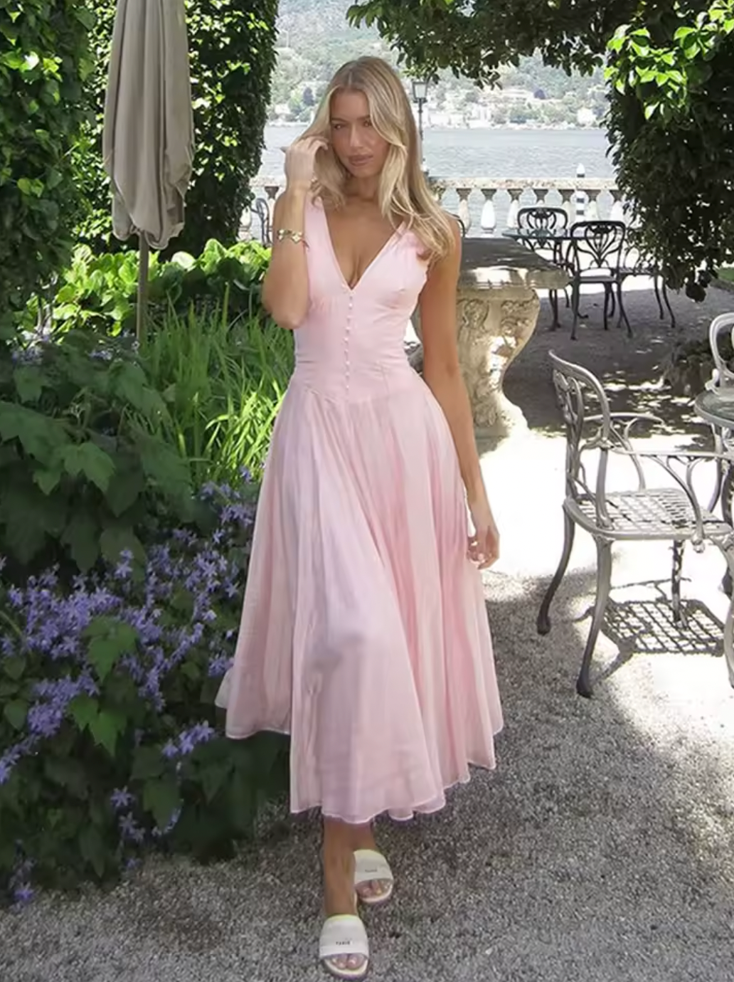 Crafted from lightweight pink chiffon, the 'Samira' midi dress combines elegance with effortless movement. Its classic V-neckline and signature boning offer a tailored silhouette that flatters the bust and defines the waist. Front buttons enhance the refined fit, while subtle pleats in the skirt create graceful flow, adapting naturally to your movements. Designed to leave a lasting impression, this dress exemplifies sophisticated style with expert attention to detail.