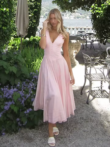Crafted from lightweight pink chiffon, the 'Samira' midi dress combines elegance with effortless movement. Its classic V-neckline and signature boning offer a tailored silhouette that flatters the bust and defines the waist. Front buttons enhance the refined fit, while subtle pleats in the skirt create graceful flow, adapting naturally to your movements. Designed to leave a lasting impression, this dress exemplifies sophisticated style with expert attention to detail.