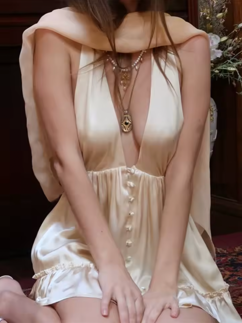 The Caroline Dress by Fait par Foutch is crafted from medium-weight 100% silk charmeuse, offering a luxurious, smooth texture that drapes elegantly. Fully lined with pure silk for enhanced comfort, it features functional silk-covered buttons and loops down the center front. Its low V-neckline and halter straps tie into an adjustable bow at the neck, providing a customizable fit. The low back design includes hidden elastic at the waist, ensuring a flattering silhouette and secure fit. 