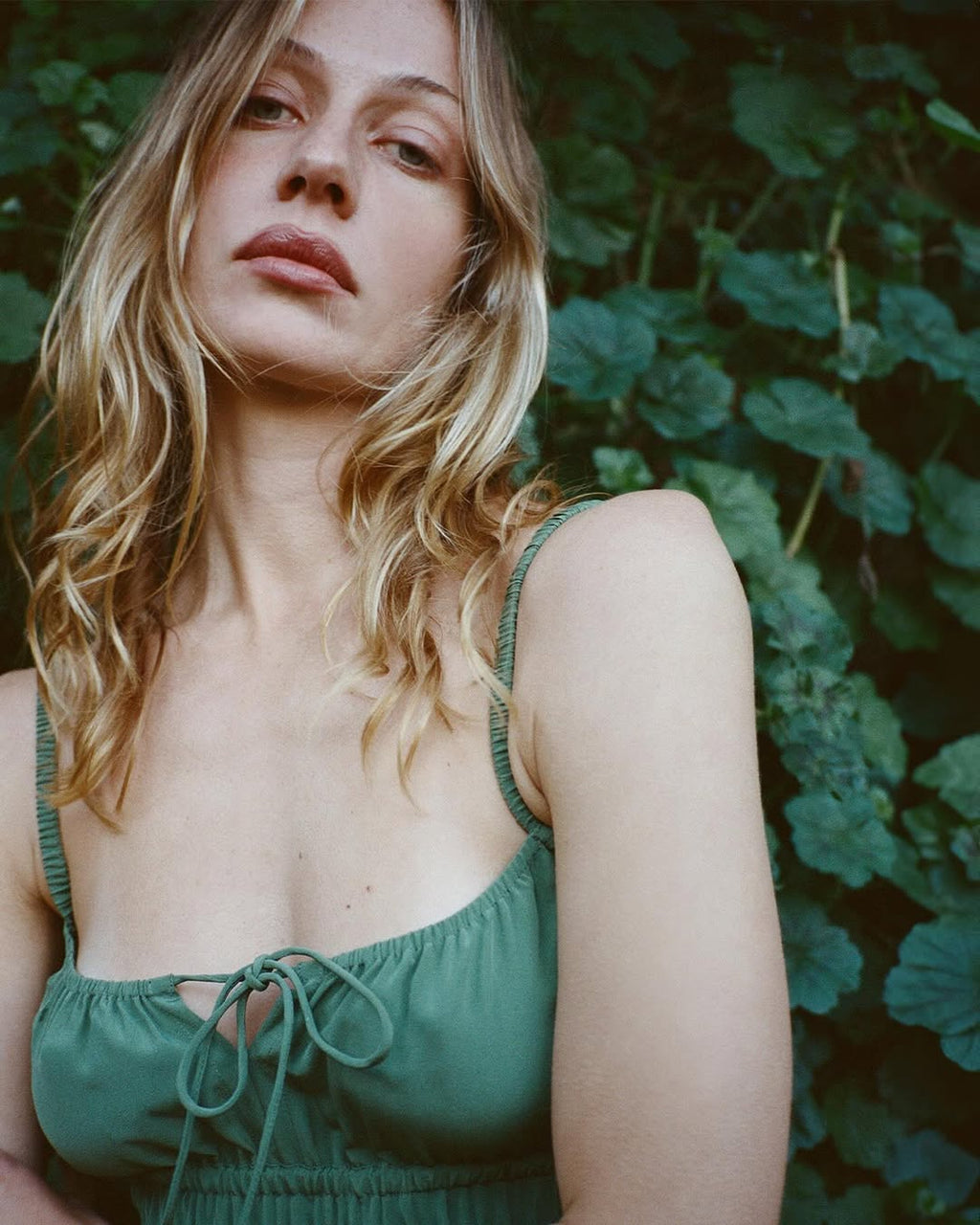 The Camille in Poison by Realisation Par blends chic minimalism with versatile design. Crafted from solid-colored silk, it features a milk-maid style bust with a keyhole detail that can be tied for added lift or left untied for a relaxed, elegant look. The form-fitting elasticated torso and back, adjustable straps, and bias-cut skirt ensure a flattering fit on various body shapes. Pair with kitten heels to complete a sophisticated yet effortlessly alluring ensemble.